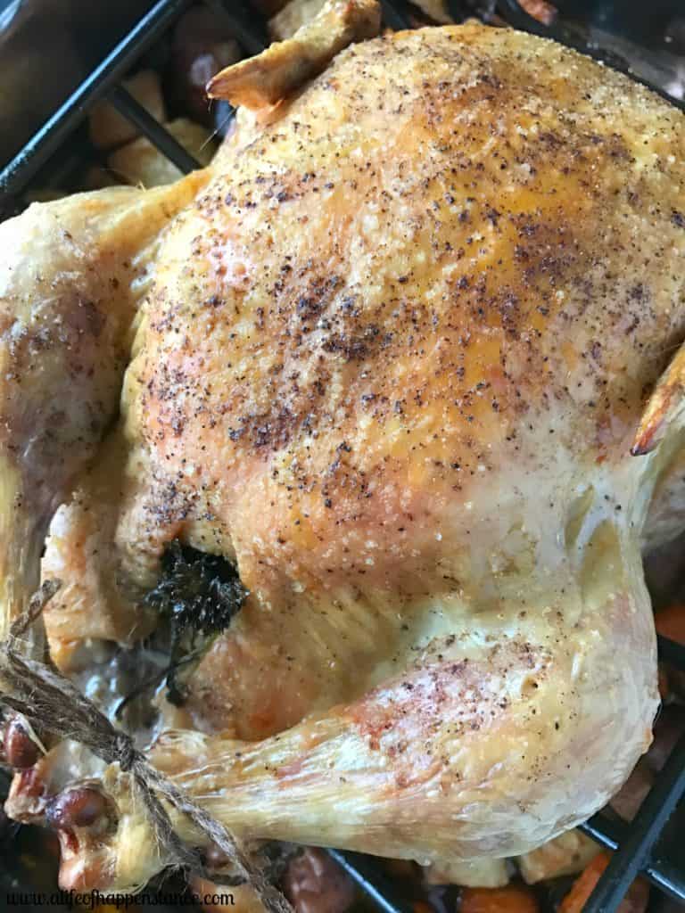An easy roast chicken with crispy skin and tender meat on a roasting pan. 