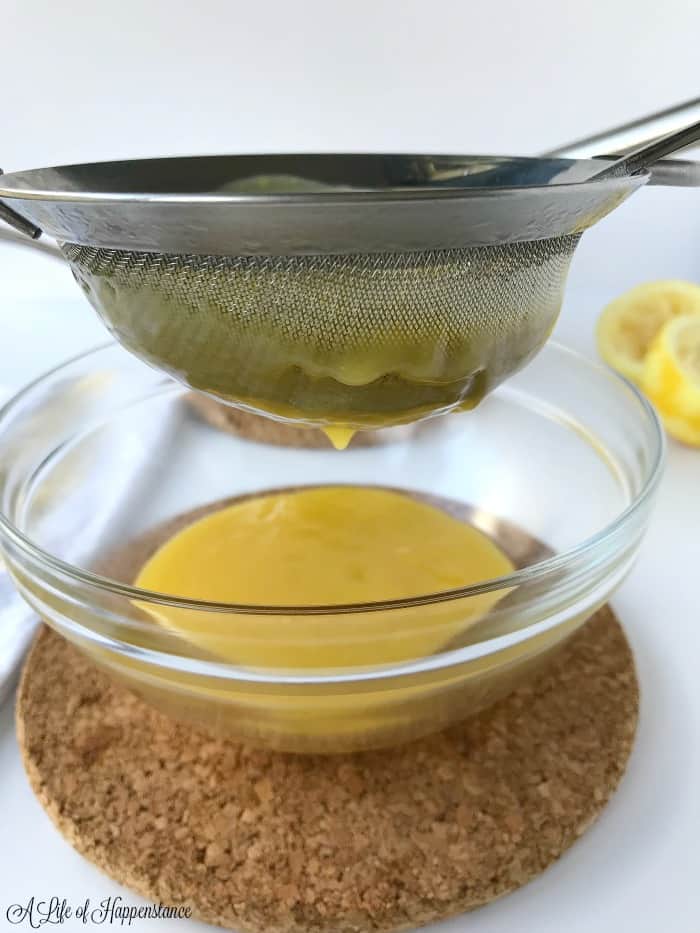 Straining the lemon curd into a small glass bowl. 