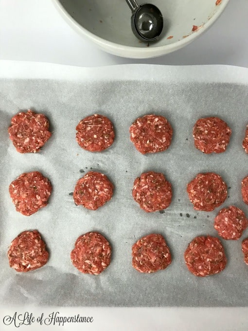 The raw homemade sausage patties on a parchment lined baking sheet. 
