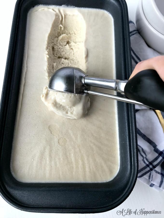 Scooping frozen vanilla cashew ice cream out of a loaf pan. 