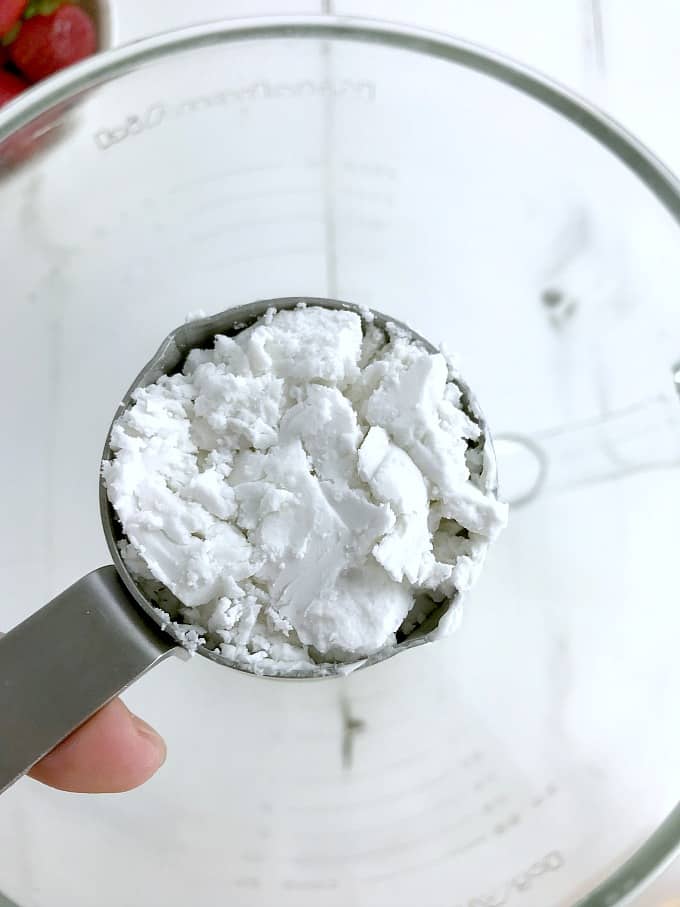 A measuring cup filled with coconut cream. 