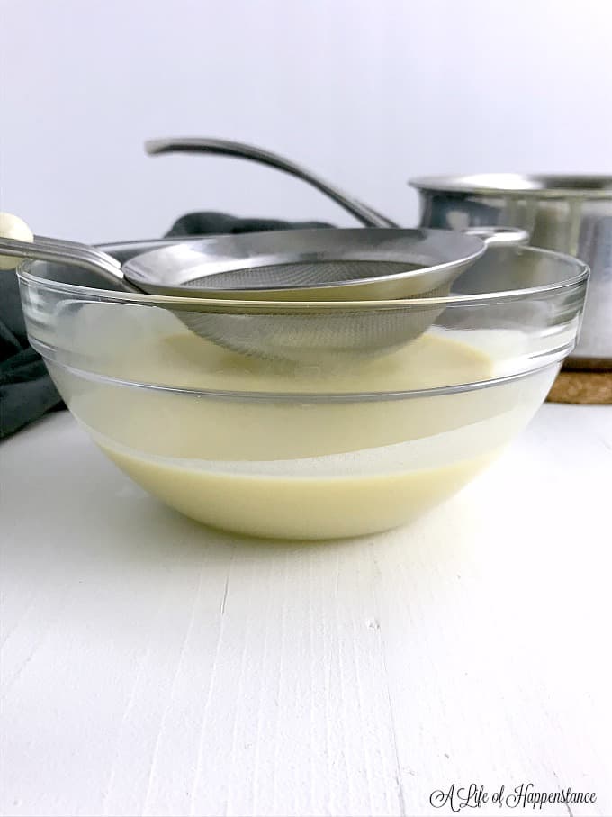 Straining the vanilla custard into a glass bowl. 