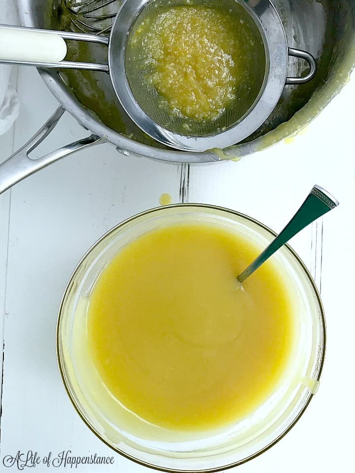 An overhead shot of the lemon curd in a glass bowl along with an empty saucepan. 