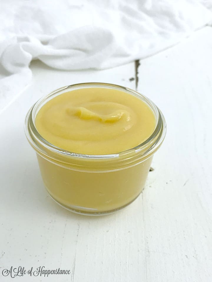 A small glass container filled with paleo lemon curd. 