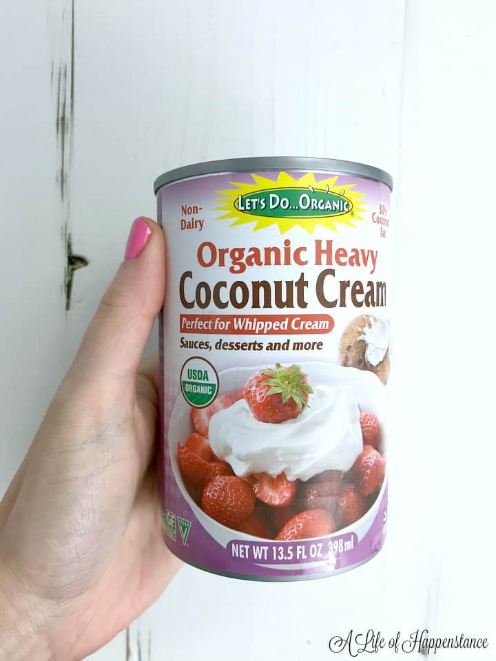 A hand holding a can of organic heavy coconut cream. 