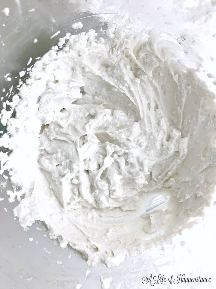 A glass bowl filled with whipped coconut cream. 
