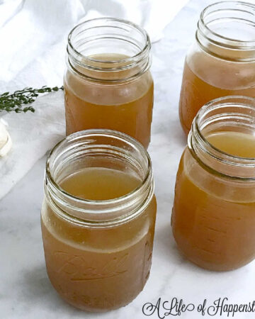Four mason jars filled with homemade vegetable broth.