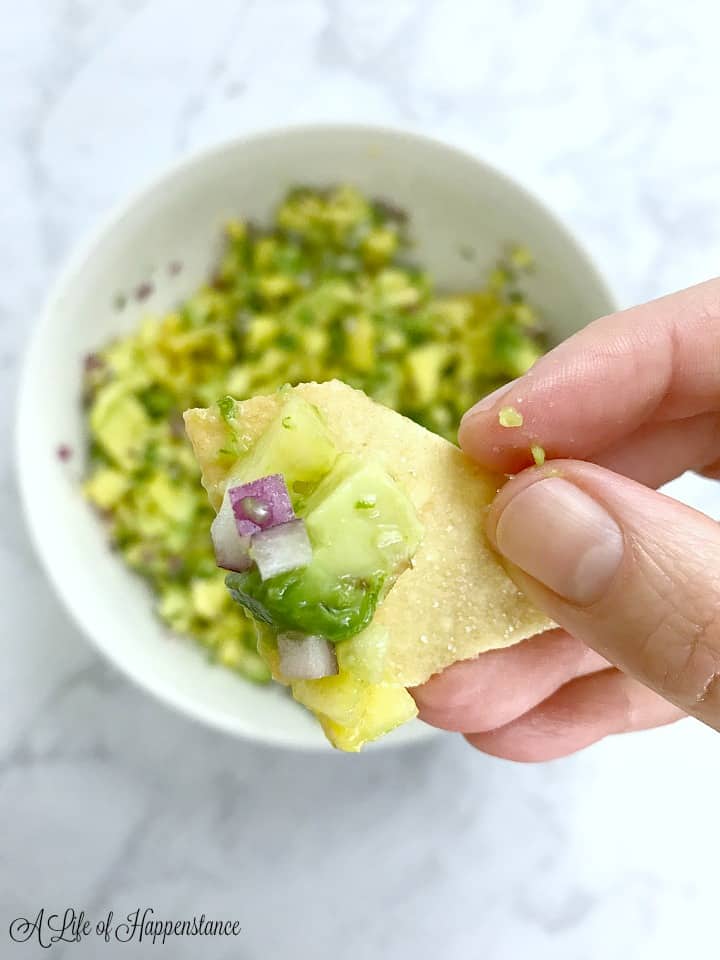 Holding a chip full of pineapple avocado salsa. 