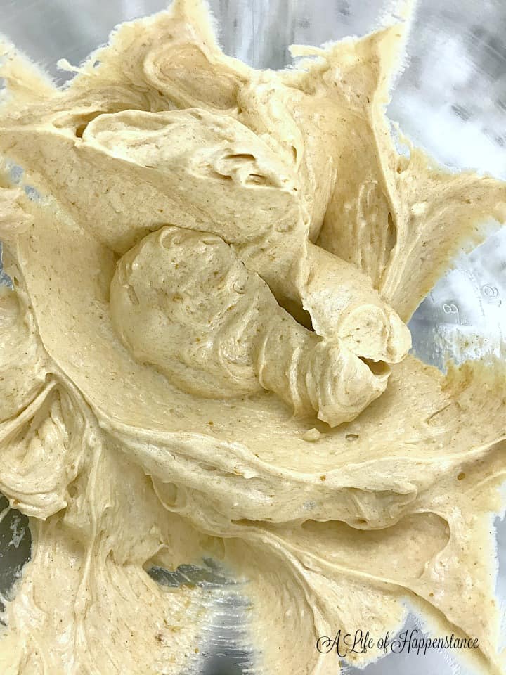 The completed pumpkin frosting in a glass mixing bowl. 