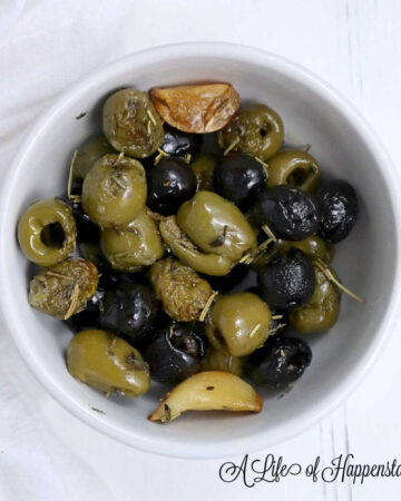 Roasted olives in a small white bowl.