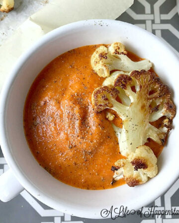 A bowl of soup garnished with roasted cauliflower florets.