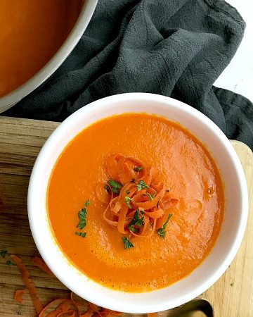 A white bowl filled with the ginger carrot soup recipe.