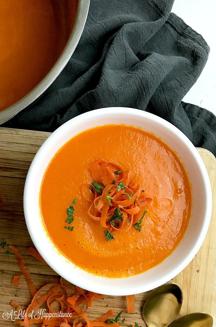A white bowl filled with the healthy carrot ginger soup. 