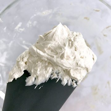 A grey spatula full of vanilla Italian meringue buttercream.