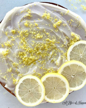 The lemon almond flour cake on a glass cutting board.